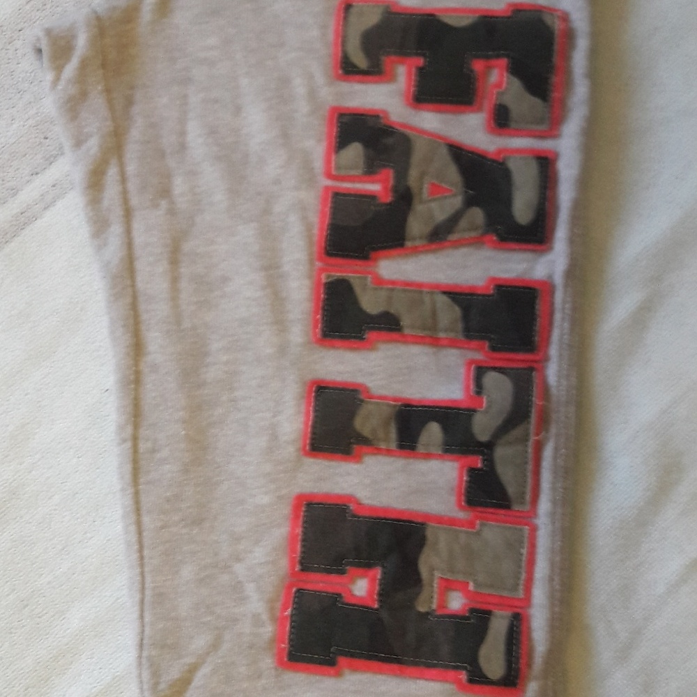 Grey sweatpants with "Faith" written across leg.